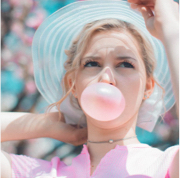 Person blowing bubble with pink bubblegum